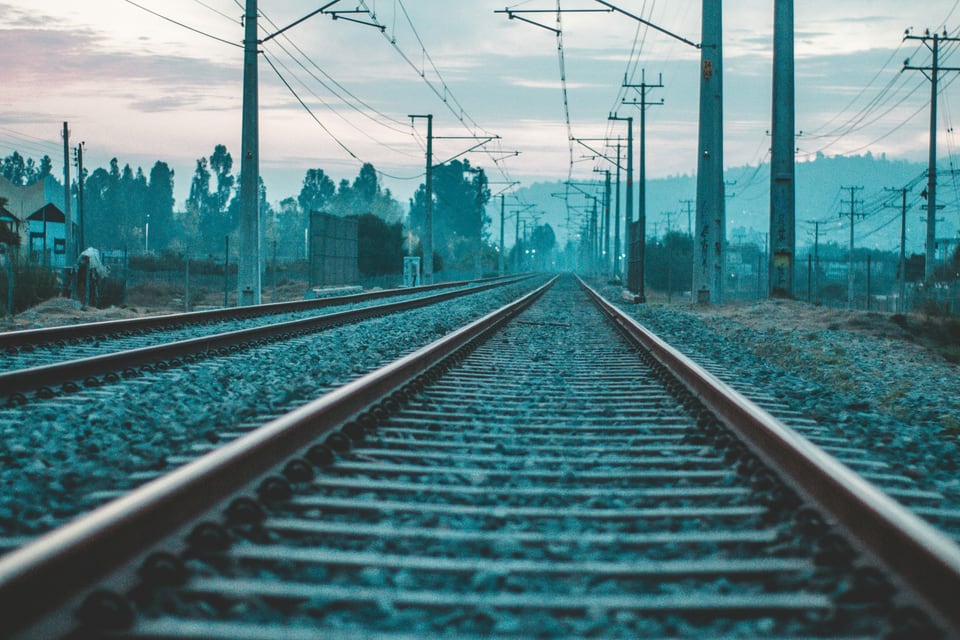 Parallel railway tracks and overhead electrical lines converging in the distance at Quilpué