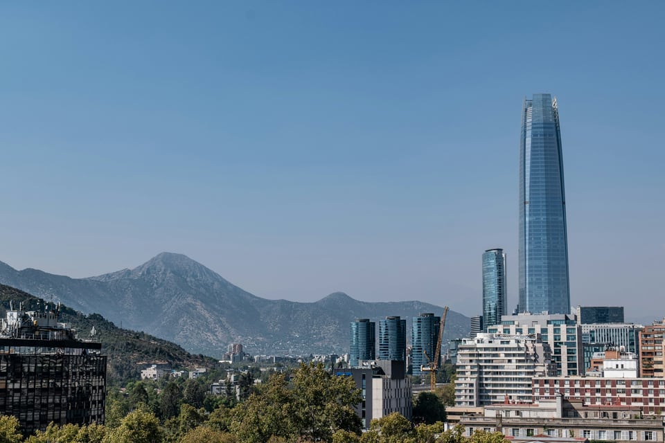 Santiago skyline with glass towers, low-rise buildings and the Andes rising behind the city