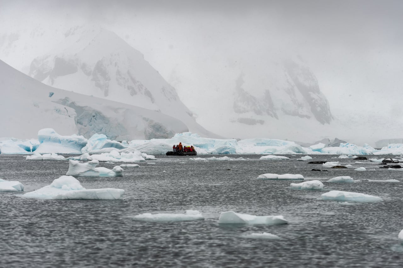 Expedition team moving across an Antarctic ice landscape